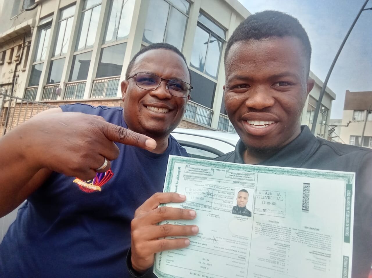 A smiling Sir Kabs learner showing her driving documents